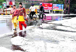 Pedestrians and cyclists at the hailstone-covered Shankaracharya Chowk on the national highway in Haridwar on Saturday