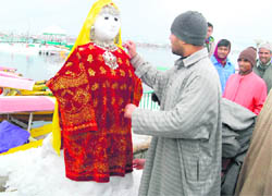 A local admires a snow woman in Srinagar