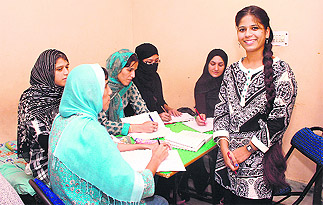 Aarzoo Hussain, extreme right, during a class with her students, Puran (face covered), Ilham, and Raheema 