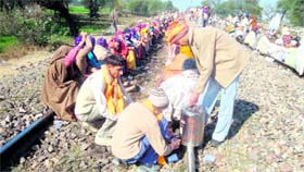 A volunteer serves tea to the agitating men and women.