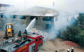 Army firemen (left) controlling the fire that broke out at Dashmesh Textiles Private Limited near the transit campus of the Central University of Punjab in Bathinda on Sunday