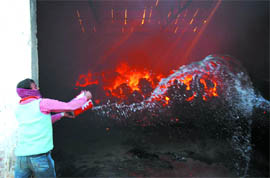 A worker tries to do his bit to extinguish the fire before the arrival of a fire tender. 