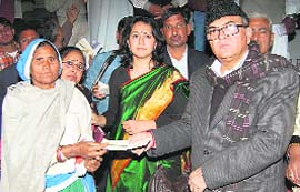 Finance Minister Ajay Singh Yadav presents a cheque to a woman beneficiary at a function in Rewari.