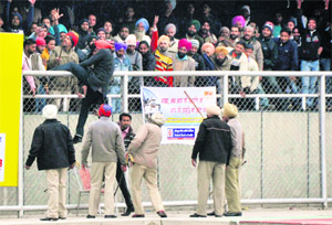 A frenzied spectator jumps over the fencing during Gurdas Manns performance in Ludhiana on Monday