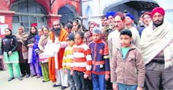 Hindu and Sikh families along with Surinder Billa (in saffron), president of the All-India Hindu Shiv Sena, at the office of the Deputy Commissioner in Amritsar on Monday.