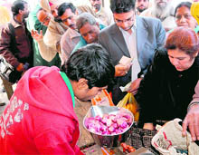 Residents queue up at a stall selling subsidised onions at the grain market in Sector 26, Chandigarh, on Tuesday