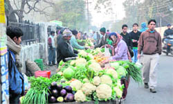 Street vendors do business on a busy road in Dehradun.