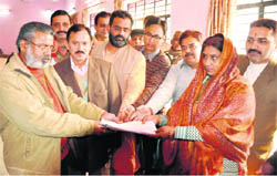 A candidate, along with supporters, submits her nomination papers at the Zila Panchayat office in Haridwar