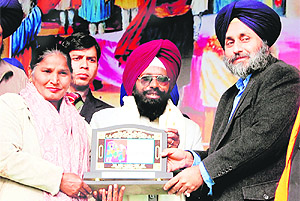 Deputy CM Sukhbir Singh Badal honours social activists Ajit Singh and his wife Satpal Kaur. Photo: Vishal Kumar