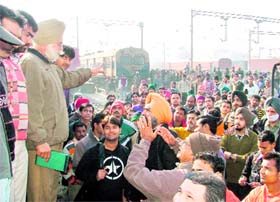 Railways and police officials persuade irate passengers to disperse and board the train so that it could resume its onward journey, in Ludhiana on Friday.