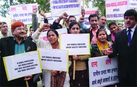 Doctors under the bannerof the Indian Medical Association (IMA)take part in a countrywide one-day protest against a proposedshort-term medical course for rural areas,at Rajghat in New Delhi on Saturday