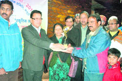 OP Uniyal, President, Municipal Council, Mussoorie, presents a trophy to Sunil Kumar during the second carrom tournament in Mussoorie 