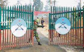 SHUTTING DOORS TO VIOLENCE: A Maoist combatant closes the gates of Shaktikhor cantonment in Chitwan, some 160 km south of Kathmandu