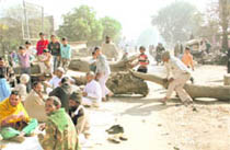 Protesters block the main road on the outskirts of Jind