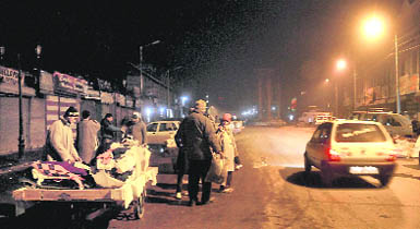 Unmindful of the tension in the run-up to the BJPs plan to hoist the National Flag at Lal Chowk on Republic Day, tourists buy woollen clothes from a roadside vendor in Srinagar on Sunday.