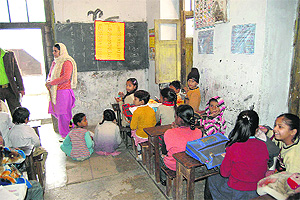 Some students of Government Senior Secondary School sit on the floor at Katra Safaid in Amritsar.