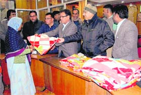 Mussoorie SDM Manoj Kumar and MC President OP Uniyal distribute blankets to the poor on the eve of Republic Day in Mussoorie