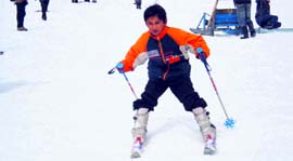 A young skier enjoys skiing on the snow-covered Solang hills.