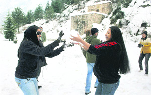 Tourists play with snow at Pari Mahal on the outskirts of Srinagar on Friday.