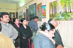 Visitors at a painting exhibition put up by women painters in Haridwar