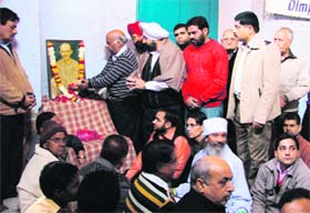 Congressmen offer garlands and flower petals at the portrait of Mahatma Gandhi on his martyrdom day in Ludhiana