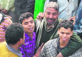 Satpal, father of Sujan, along with his two sons, mourns his death in Ludhiana
