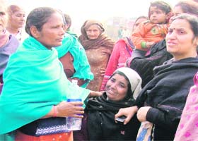 The grieving mother of Sujan being consoled by women in Ludhiana