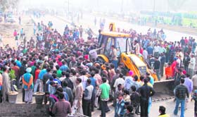 A crowd gathered at the site where Sujan Singh fell into a manhole in Ludhiana