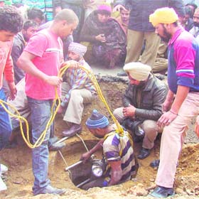 An MC employee enters the manhole to find Sujan in Ludhiana