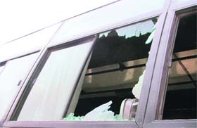 A windowpane of a bus broken by angry protesters