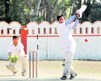 A player hits the ball in a match of the 60th District Cricket League held at the Survey Grounds in Dehradun on Monday.