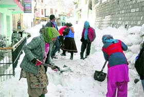 Labourers of the PWD clear a snow-covered road on the Mall at Keylong in Lahaul-Spiti district on Monday.