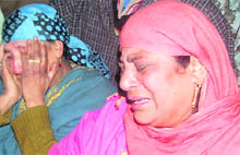 Grieving relatives of two sisters, Akhtara and Arifa,