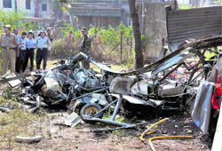 Police officials at the site where the Army helicopter crashed in a residential area
