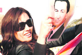 A supporter of Egyptian President Hosni Mubarak holds his picture as she waves the national flag during a demonstration in Cairo 
