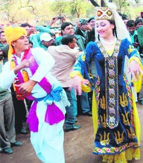 An artiste from abroad shakes a leg with an Indian folk dancer at Surajkund Crafts Mela in Faridabad