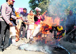 Workers of the Uttarakhand Kranti Dal (Panwar faction) burn an effigy of the Chief Minister in front of the office of the Garhwal Mandal Vikas Nigam in Dehradun on Wednesday