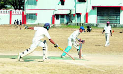 A batsman tries to reach his crease during a match in the Dehradun District Cricket League in Dehradun