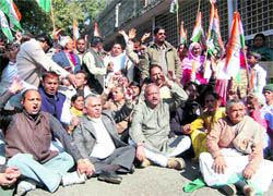 Congress workers hold a dharna against the state BJP Government in front of the Dehradun District Magistrates office on Monday