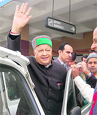 Union Minister Virbhadra Singh waves at his supporters at the Kangra airport on Friday.