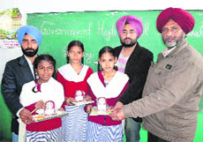 Winners of the spelling competition proudly display their prizes at Government High School in Ludhiana on Friday.