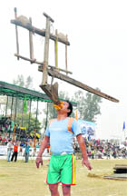 Balbir Singh lifts a plough with his teeth.