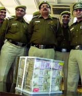 Delhi police officers with Rs 63.5 lakh at the police headquarters in New Delhi on Saturday.
