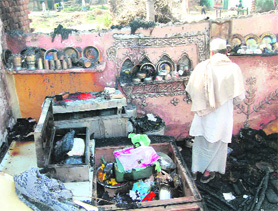 An old man checks out his kitchen after a fire gutted several houses in Ibrahimpur village on the outskirts of Haridwar on Saturday. 
