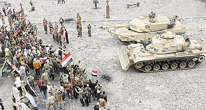 Anti-government demonstrators face army tanks in Cairos Tahrir square on Saturday.  AFP