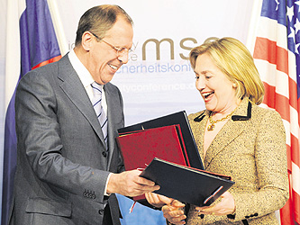 US Secretary of State Hillary Clinton and Russian Foreign Minister Sergei Lavrov exchange documents at the 47th Munich Security Conference on Saturday.