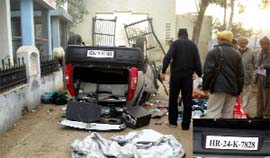 Policemen examine the car that overturned after crashing into the cremation ground gate near Abohar on Sunday.