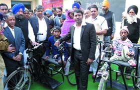 Bathinda DC S. Karuna Raju and SAD area in-charge Sarup Chand Singla distributing tricycles to the physically challenged on Sunday to mark the 11th death anniversary of the latters father.