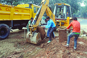 NDMC workers working to fix the pipeline that burst on Saturday evening at Ashok Road, near Hotel Le Meridian, in New Delhi on Sunday. Tribune photo: Manas Ranjan Bhui