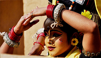An artiste watches her co-star at the Surajkund Crafts Mela in Faridabad. 